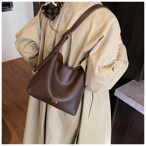 Détails rapprochés de la texture en cuir grainé marron foncé sur ce sac seau élégant