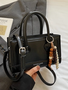 Retro black leather handbag with chic wooden bead charm and silver hardware accents