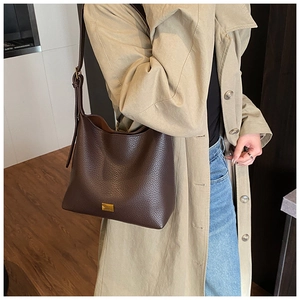 Détail du sac seau en cuir grainé marron foncé avec boucle métallique dorée élégante