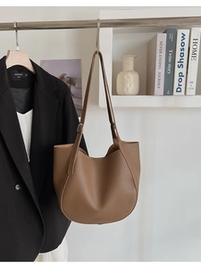 Detail view of brown lychee grain faux leather tote bag with adjustable shoulder strap