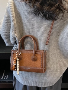 Chic brown PU leather crossbody handbag with wooden beads shown on female model
