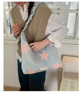 Detail of light blue hobo tote bag with pink plush star and ruched cloud strap