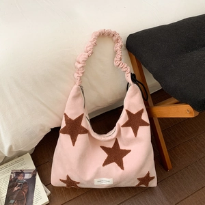 Detailed view of pink plush star handbag with soft texture and white brand label