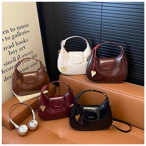 Collection of shiny patent leather crescent bags in five colors with golden heart charms