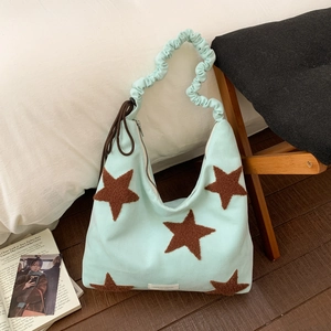Detail of mint green tote bag with brown plush stars and ruched handle design