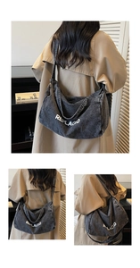 Detail of grey vintage denim hobo bag with adjustable strap and REPLACED text logo
