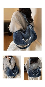 Detail of large navy washed denim hobo bag featuring white REPLACED lettering print