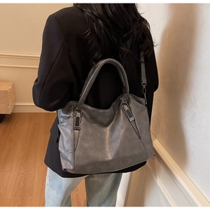 Detail of dark grey retro leather bag texture with vintage finish and metal hooks