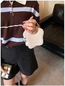 Détail du sac à main blanc en forme d'étoile avec logo Helahe et poignée en perles