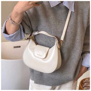 Minimalist cream white hobo bag with gold hardware shown on model for daily style