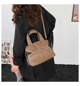 Detailed view of khaki brown tote bag with cross-stitched leather texture and shoulder strap