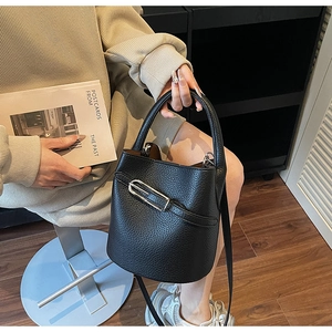 Detail of black lychee grain leather bucket bag with silver chain and shoulder strap