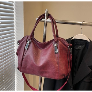 Macro shot of burgundy tote bag with vintage faux leather texture and metallic buckle details
