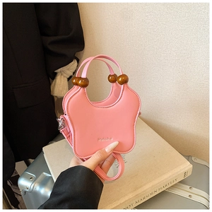 Sac à main rose en forme de papillon avec poignée en perles de bois et détails embossés