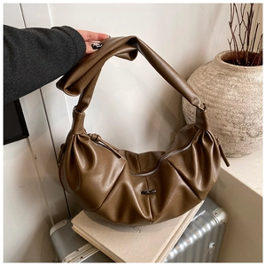 Detail of coffee brown pleated crescent bag with unique knotted wide strap design