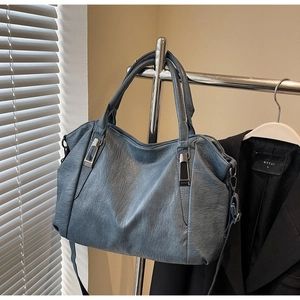 Close-up of retro texture and silver metal hardware on a large blue-gray tote bag