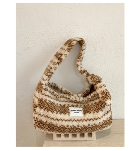 Détail du motif jacquard ethnique et de l'étiquette faite main sur le sac fourre-tout en peluche