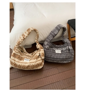 Détail de sacs bandoulière en polaire avec motifs jacquard géométriques dans un cadre chaleureux
