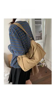 Detail of khaki drawstring crossbody bag with pleated side and secure zipper closure
