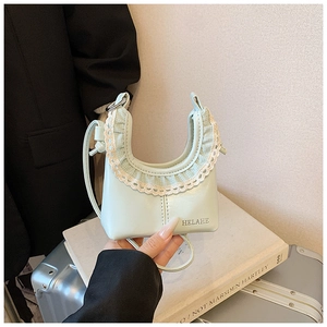 Detailed view of mint green mini cloud bag featuring delicate white lace trim and logo