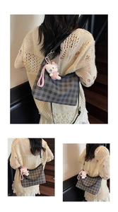 Détail du sac hobo à carreaux avec porte-clés en peluche rose et bandoulière réglable