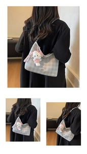 Détail du sac hobo à damier gris clair avec un joli pendentif chaton en peluche blanc