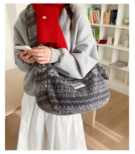 Gros plan d'un sac cabas en polaire grise avec écharpe rouge dans un décor de bureau
