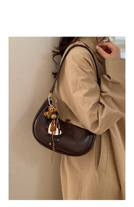 Détail du sac hobo marron avec patch cœur léopard et breloques en métal décoratives
