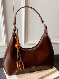 Sac sous le bras en cuir verni marron foncé avec pompon en perles de bois sur socle
