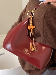 Sac hobo demi-lune bordeaux avec anneaux dorés et pendentif en perles de bois naturel