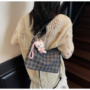 Détail du sac hobo à carreaux avec breloque chaton rose et boucle en métal argenté
