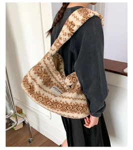 Détail du sac hobo en peluche avec motifs géométriques et étiquette de marque latérale