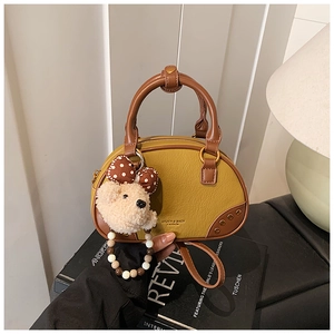 Close-up of retro color-block bowling bag with cute plush bear charm and metallic logo
