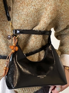 Sac sous le bras en cuir noir brillant avec logo doré et breloque en bois décorative