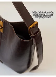 Detailed close-up of dark brown leather texture and adjustable golden metal buckle