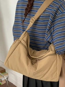 Large khaki crossbody bag with multiple zippers and wide adjustable strap for women