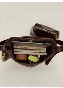 Macro view of spacious dark brown leather tote bag interior with inner pouch and metal buckle