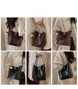 Macro view of retro oil wax leather tote bag with gold lock and leopard bear charm