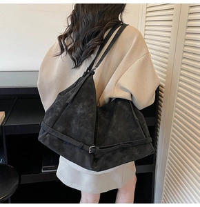 Close-up of the black matte suede tote bag showing soft texture and adjustable buckle straps