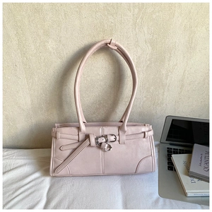 Detail view of pink rectangular handbag with metal buckles and leather strap decoration