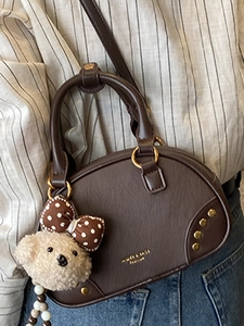 Vintage brown leather bowling bag with gold handles and cute teddy bear pendant