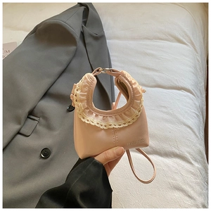 Close-up of pink leather tote bag with elegant white lace trim and shoulder strap detail