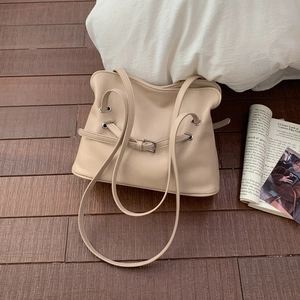 Détail du sac fourre-tout beige en cuir synthétique avec boucle argentée sur bois