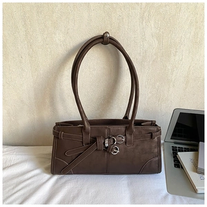 Detail shot of brown vintage PU leather bag with silver buckles and decorative belt straps