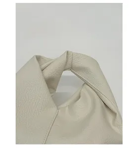 Gros plan sur la poignée plissée beige avec texture cuir de grain de litchi haut de gamme
