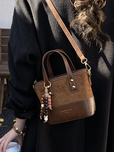 Brown vintage leather crossbody bag with wooden bead charm and top handle for women