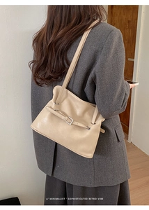 Gros plan sur le sac fourre-tout plissé beige avec boucle sur une veste grise