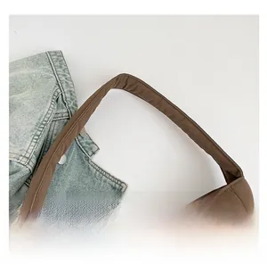 Detailed macro view of the wide comfortable brown shoulder strap on a large tote bag