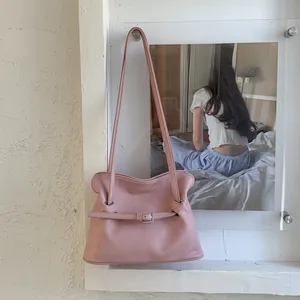 Détail du sac à bandoulière en cuir plissé rose avec une boucle métallique aimantée