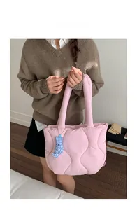 Detail view of pink quilted tote bag with cute bear charm and soft padded texture